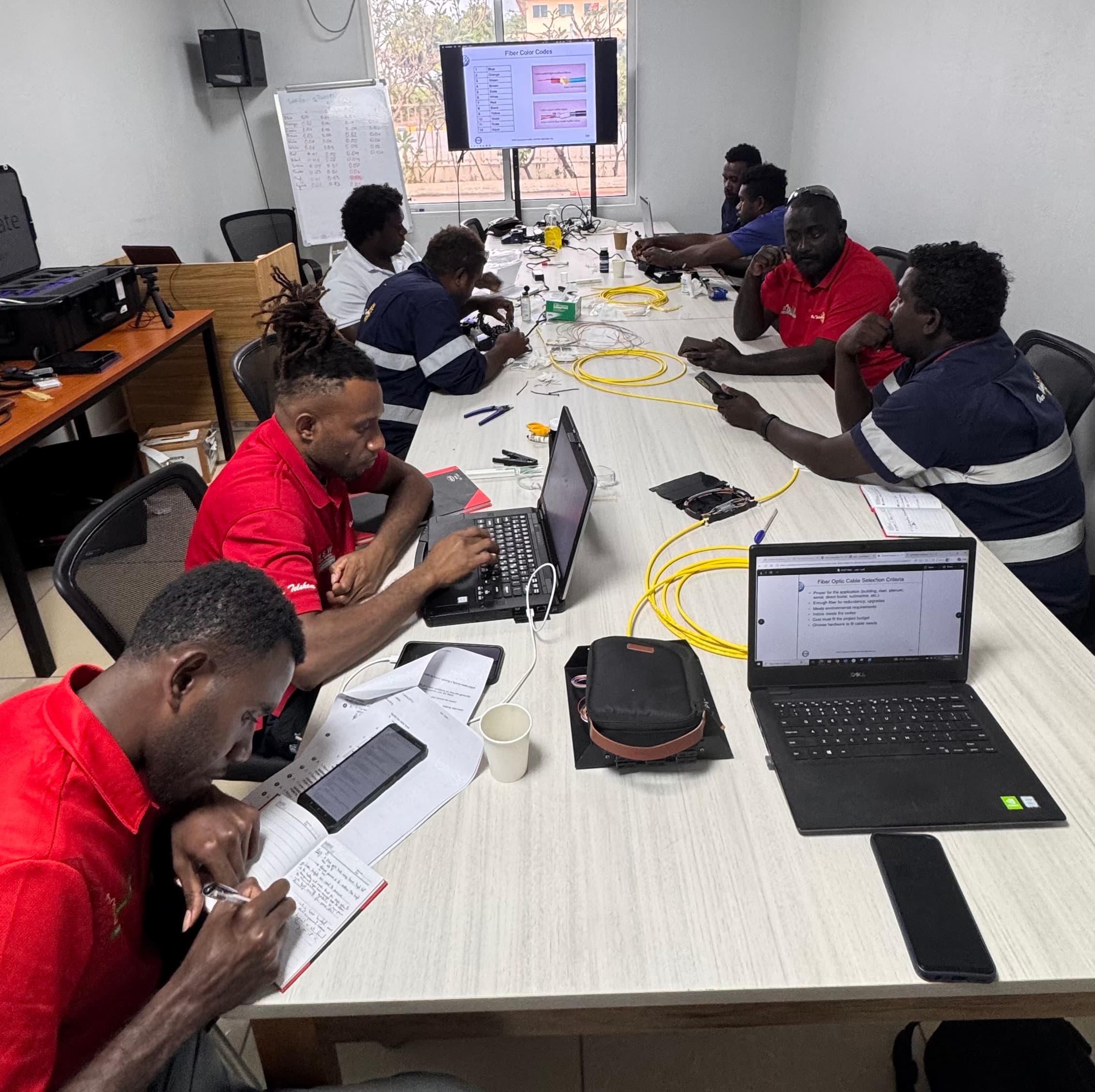 Participants working with fibre-optic materials during practical technical training in Honiara